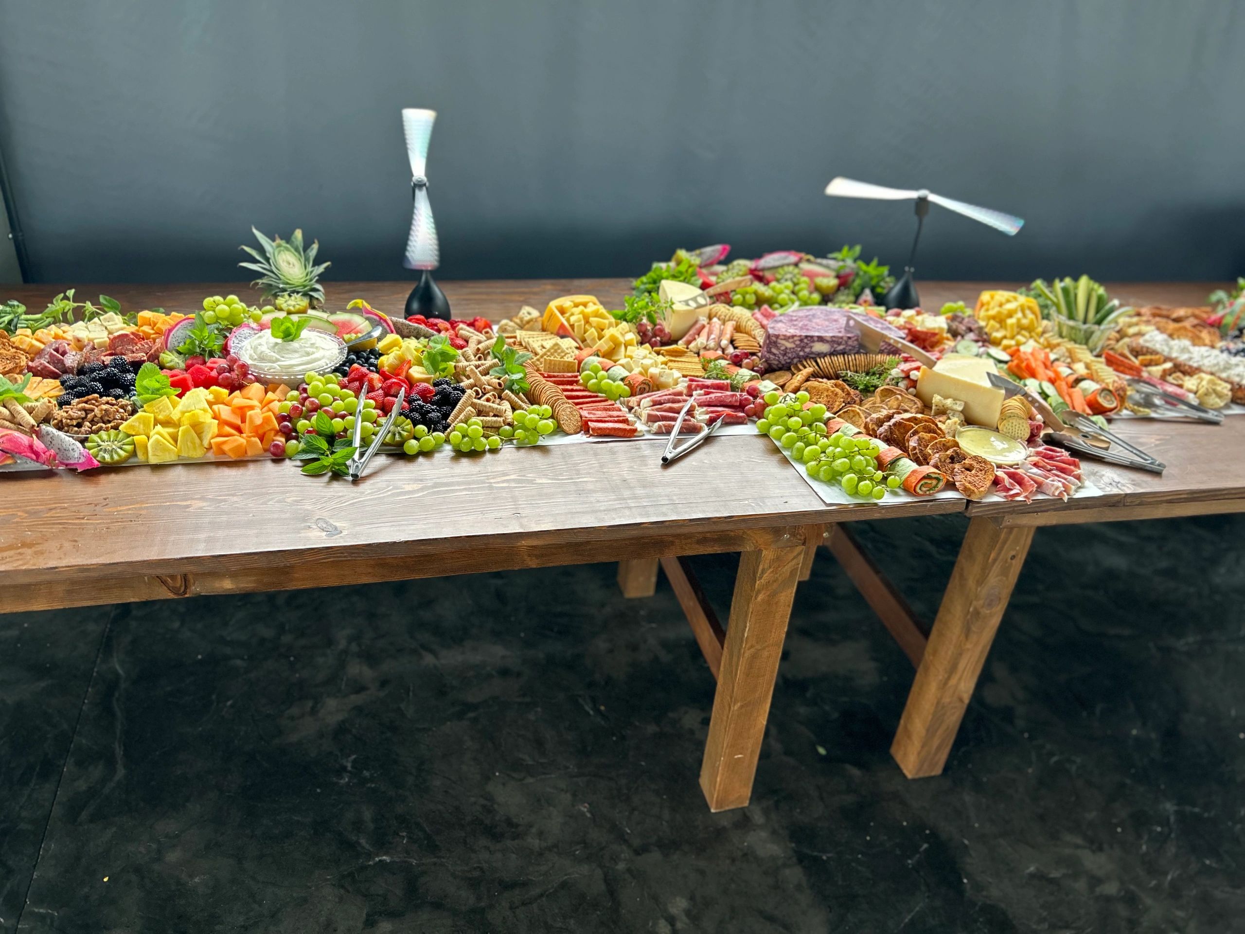 Charcuterie grazing table spread with meats, cheeses, fruit and vegetables