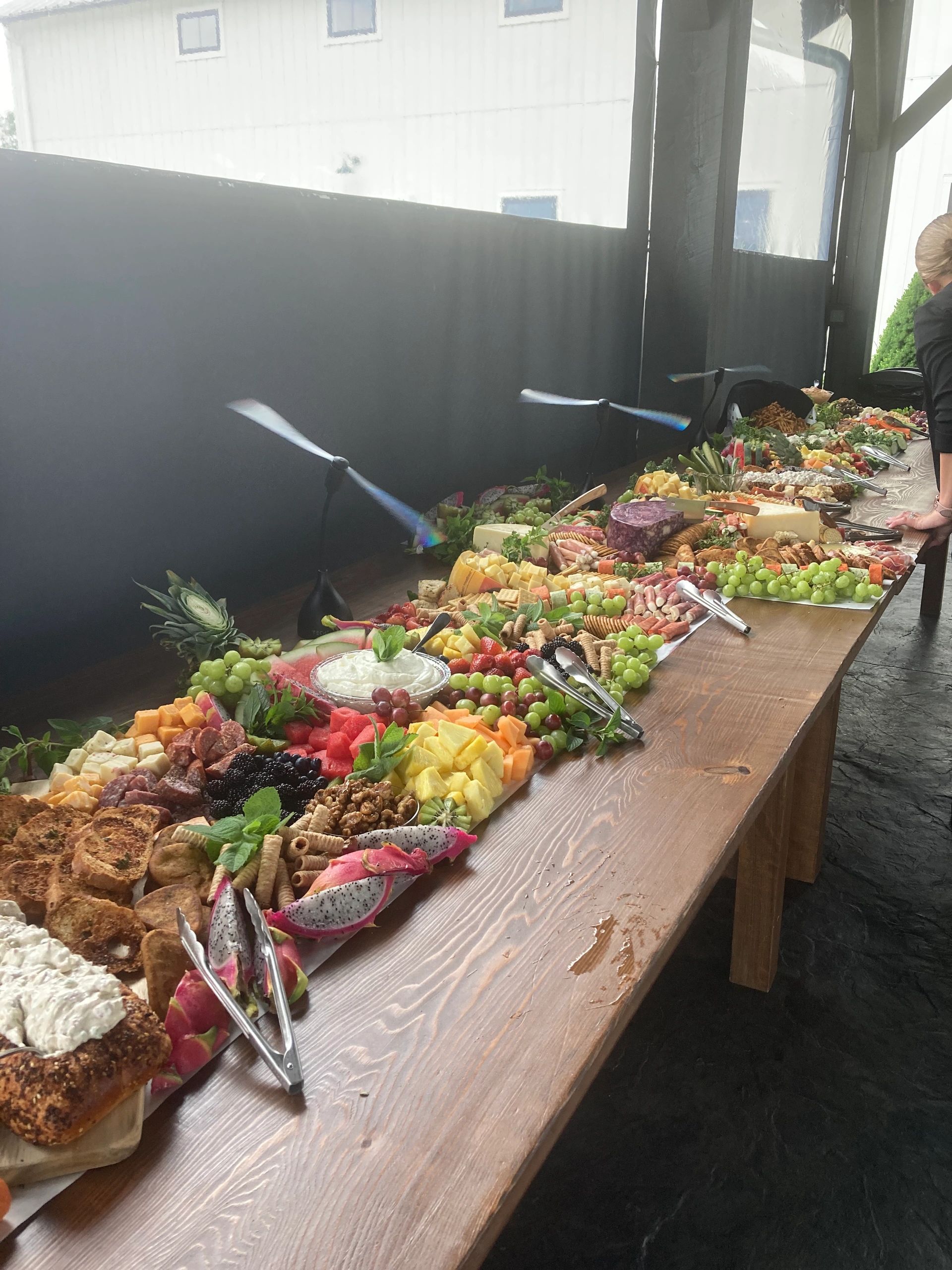 Catering buffet spread with cured meats, cheeses, and produce